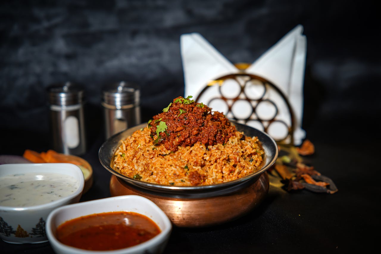 services-03 Aromatic biryani served in a copper bowl with spices and sauces. Perfect for food photography enthusiasts.