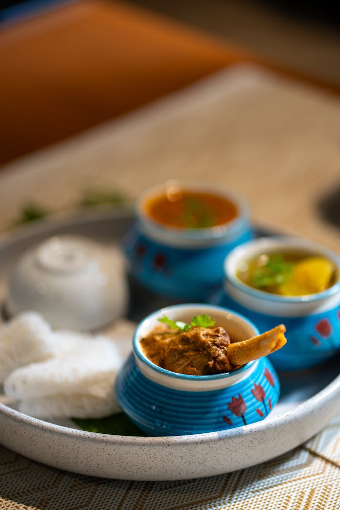 Close-up of a traditional Indian meal featuring curry and rice in vibrant ceramic bowls.